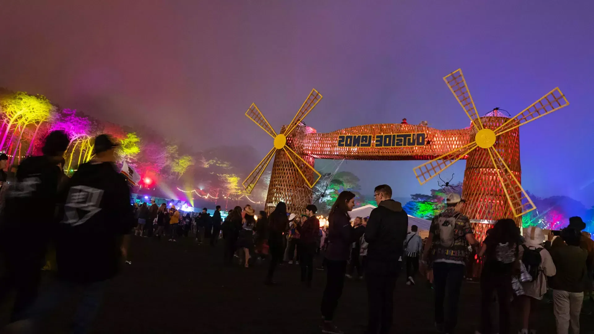 Uma multidão de frequentadores do festival é fotografada à noite em meio às luzes de neon no festival de música Outside Lands, em São Francisco.