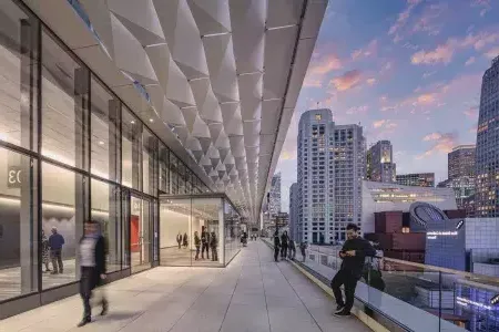 Meeting attendees stand and stroll on a balcony at Moscone Center South in San Francisco.