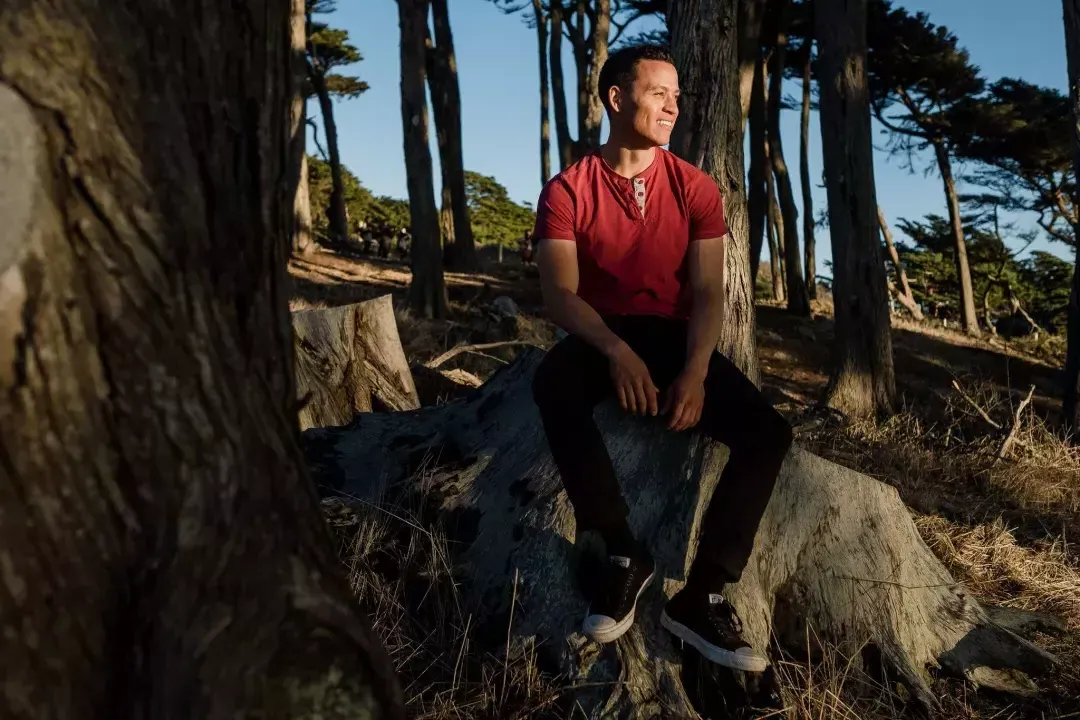 Nick Whittlesey sitting on a tree stump.