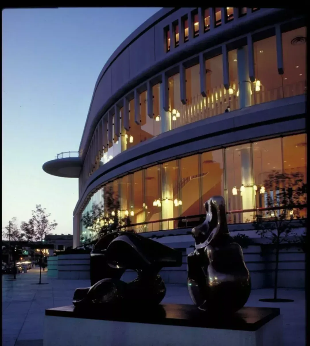 Sculpture in front of symphony hall lit up at night