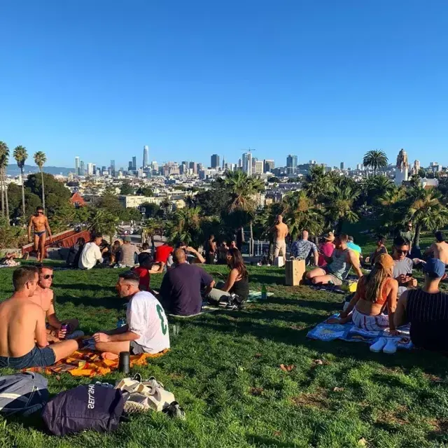 Gruppen von Einheimischen und Besuchern genießen Picknicks im Dolores Park.