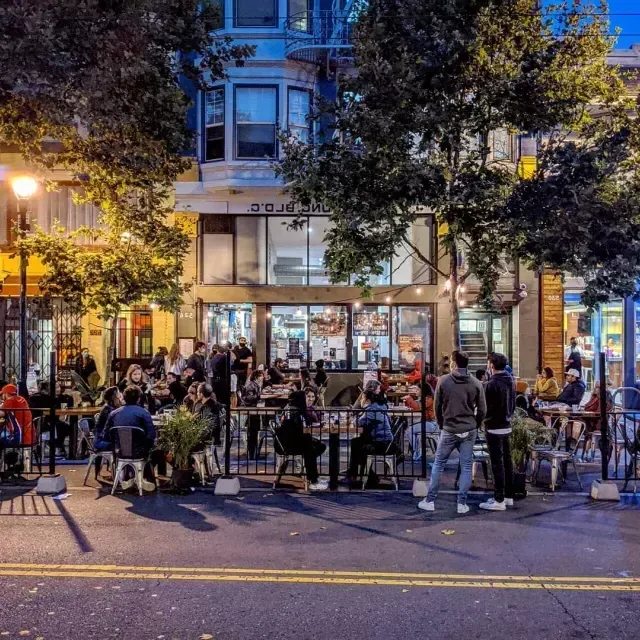 Una folla si gode cibo e bevande lungo Valencia Street a San Francisco