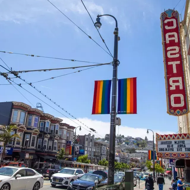 O bairro Castro, em São Francisco, com a placa do Teatro Castro e bandeiras arco-íris em primeiro plano.